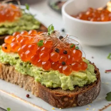 Avocado toast with salmon roe on a white plate