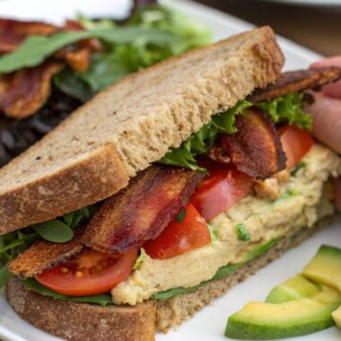 Healthy sandwich with crispy beef bacon, lettuce, and tomato on whole-grain bread.