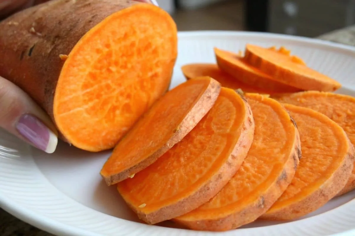 A vibrant close-up of an orange sweet potato sliced open, showcasing its rich color and texture.